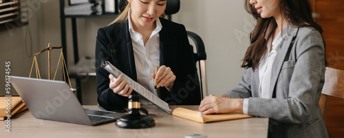 Judge gavel with scales of justice, Business and lawyer or counselor consulting and discussing contract papers with laptop and tablet at law firm in office.