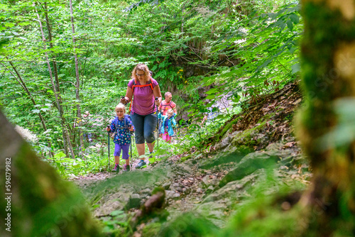 Junge Familie mit Kindern bei einer Wanderung im schattigen Wald