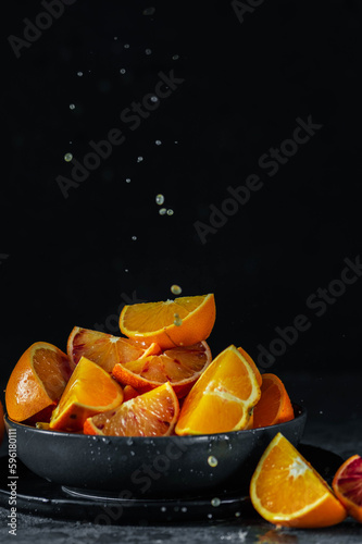 Fresh orange fruits on a plate on dark background
