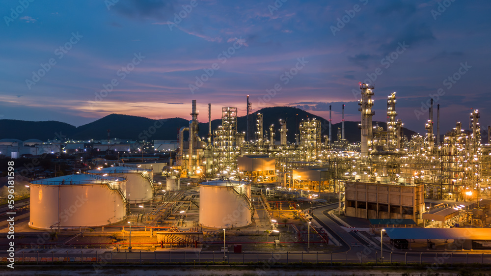 Aerial view white oil storage tank and oil refinery factory plant at night form industry zone, Oil refinery and petrochemical plant factory, Business oil and gas industrial factory power and energy.