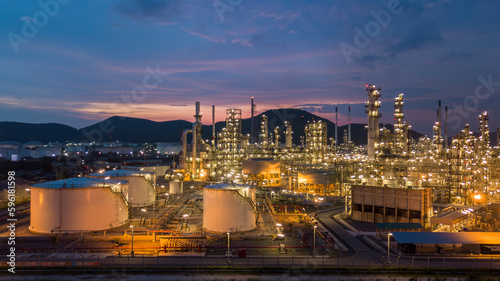 Aerial view white oil storage tank and oil refinery factory plant at night form industry zone, Oil refinery and petrochemical plant factory, Business oil and gas industrial factory power and energy.