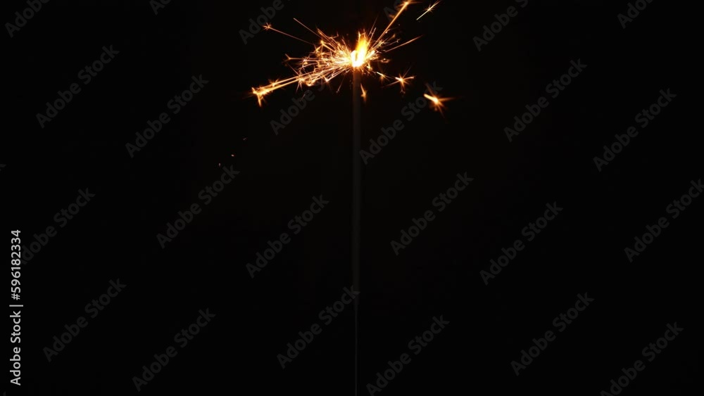sparkler lit with matches and burning fire on dark black background. sparkler lit with matches and burning fire on dark black background.