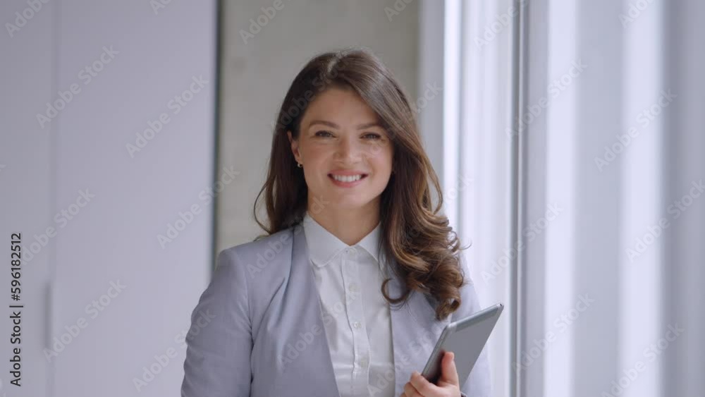 Pretty young woman working on digital tablet in the office hallway Pretty young woman working on digital tablet in the office hallway