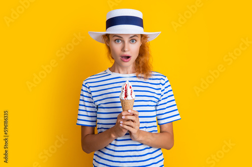 shocked summer girl with cone icecream isolated on yellow. summer girl with cone icecream