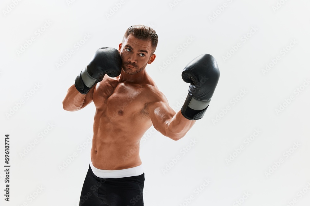 Man athletic bodybuilder poses in boxing gloves with nude torso abs in full-length background, boxing and martial arts. Advertising, sports, active lifestyle, competition, challenge concept. Man athletic bodybuilder poses in boxing gloves with nude torso abs in full-length background, boxing and martial arts. Advertising, sports, active lifestyle, competition, challenge concept.