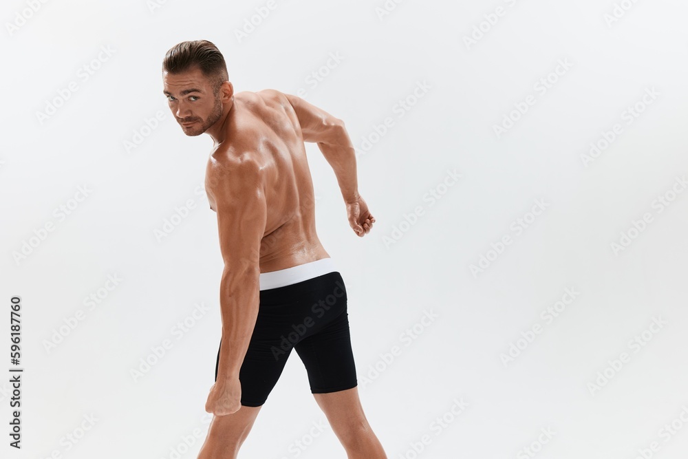 Man athletic body bodybuilder in briefs with naked torso abs full-length in the background, fitness classes. Advertising, sports, active lifestyle, competition, challenge concept. Man athletic body bodybuilder in briefs with naked torso abs full-length in the background, fitness classes. Advertising, sports, active lifestyle, competition, challenge concept.