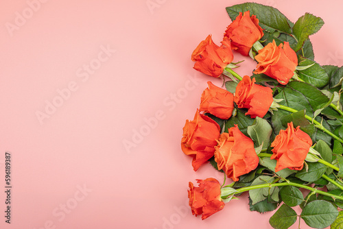 Bouquet of fresh bright roses on pastel pink background. Romantic gift concept, greeting card