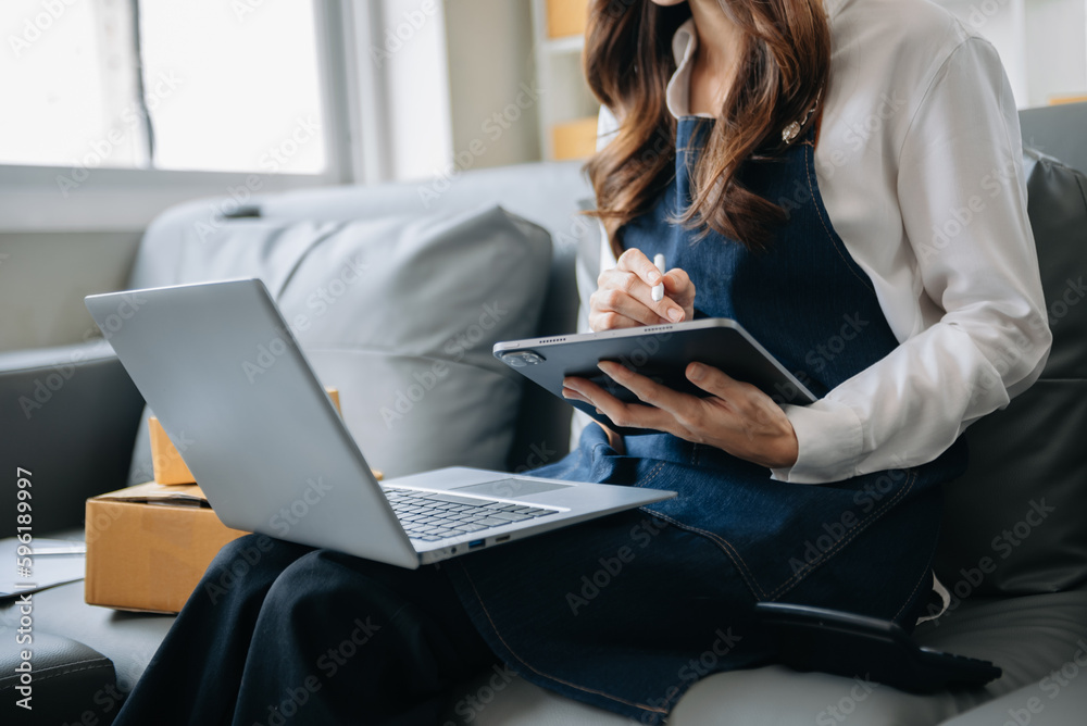 Woman hand using a laptop, smartphone and tablet and writing notebook at the office of her business online shopping. In home . Woman hand using a laptop, smartphone and tablet and writing notebook at the office of her business online shopping. In home .