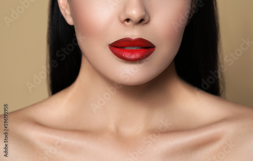 Young woman wearing beautiful red lipstick on beige background  closeup