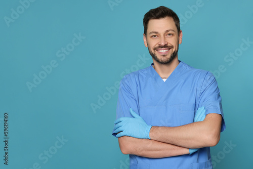 Doctor or medical assistant (male nurse) in uniform on turquoise background. Space for text