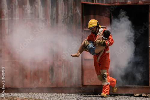 The firefighter bravely carried a child out of a smoke filled and dangerous place.