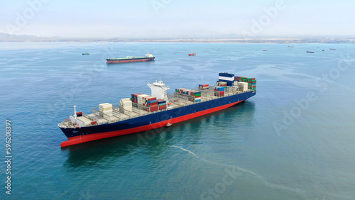 Aerial view of blue hull color ultra large container ship in discharged condition at anchor near port Callao, Lima, Peru awaiting for enter to port.
