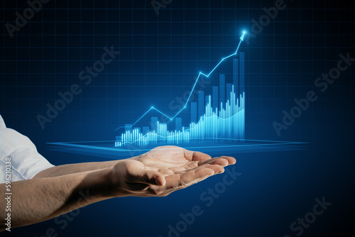 Close up of man hand holding growing business chart on blurry background. Business strategy development, financial growth and success plan.