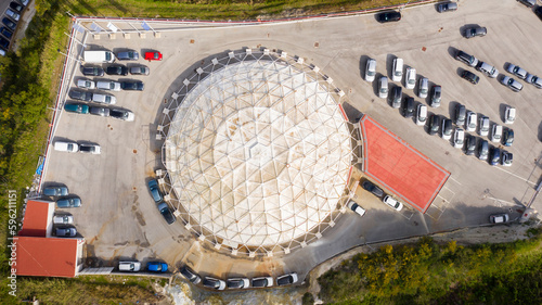 Aerial view of a white and circular warehouse.