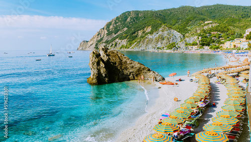 Fototapeta Naklejka Na Ścianę i Meble -  Chairs and umbrellas fill the spiaggia di fegina beach , the beach village of Monterosso Italy