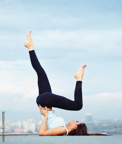 Fitness, yoga and woman on roof in city, stretching legs and back for wellness and balance with healthy body. Health care, pilates and mindfulness, zen workout for girl and view of cityscape rooftop.