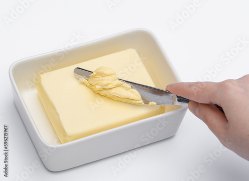 kostka masła w maselniczce, nóż wbijany w masło 