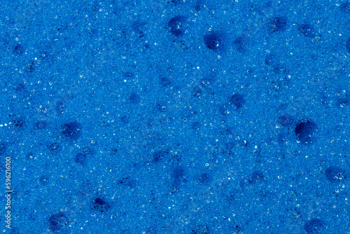 Struktura wzór niebieskiej gąbki w powiększeniu makro, widoczne pęcherzyki bąbelki. Kolor głęboki, intensywny błękit z dziurkami
