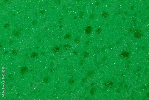 Tapeta zielone tło z gąbki do naczyń. W zbliżeniu makro z dziurkami. 