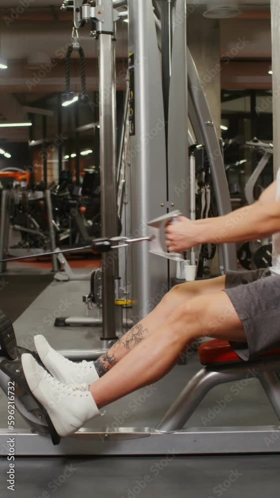 A young man of European appearance, athletic physique is engaged in the gymnasium, doing exercises to look at the muscles of the chest on a modern simulator. Side videography A young man of European appearance, athletic physique is engaged in the gymnasium, doing exercises to look at the muscles of the chest on a modern simulator. Side videography