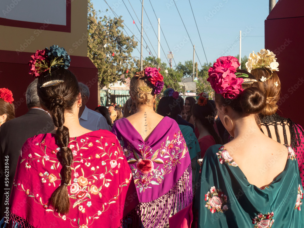 Obraz premium Jóvenes camino de la feria de Abril 2023 de Sevilla / Young people on their way to the April 2023 fair in Seville