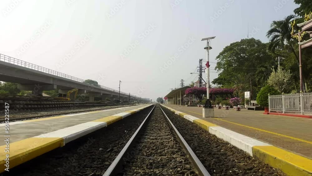 Looking down train tracks near a train station on a summers day Looking down train tracks near a train station on a summers day