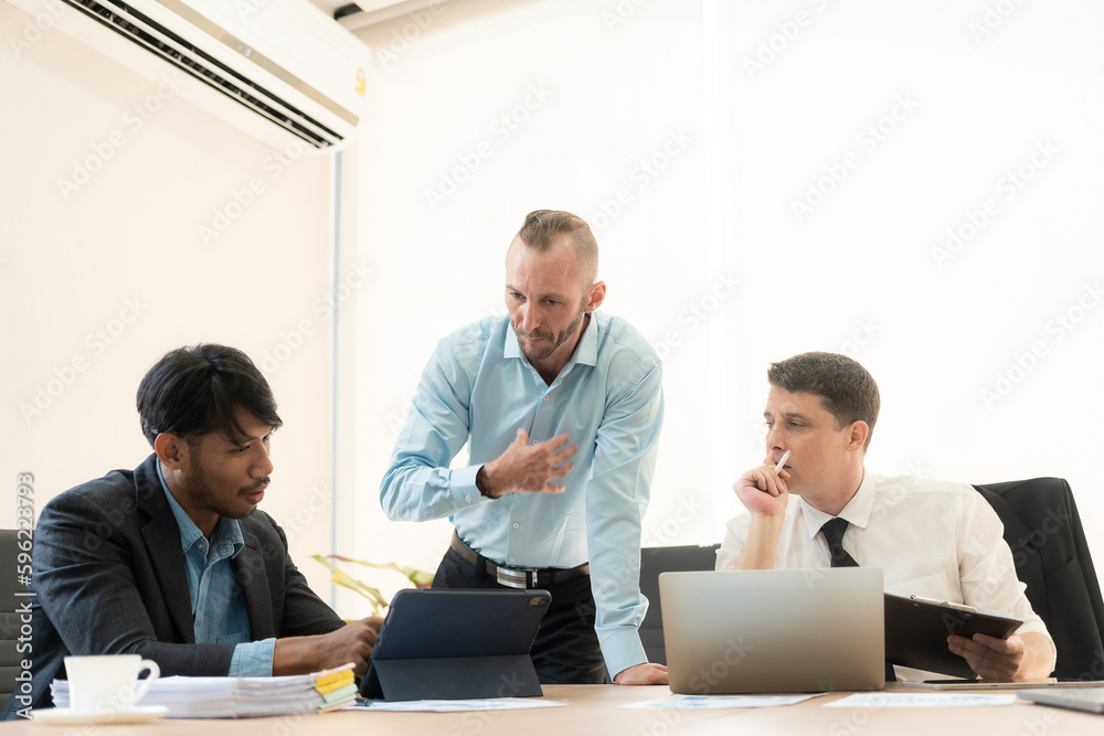 Investment advisor meeting of three businessmen analyzing company financial report, balance sheet, working with chart papers for stock market. Office Investment advisor meeting of three businessmen analyzing company financial report, balance sheet, working with chart papers for stock market. Office