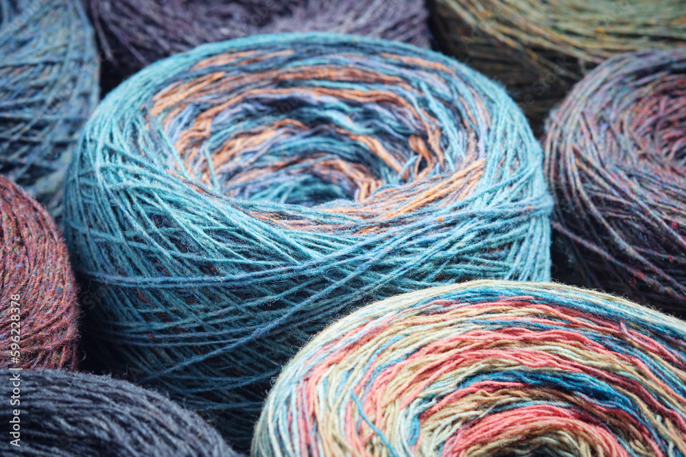 Round skeins of organic multi-coloured lambswool yarn.