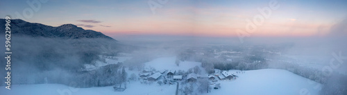 Germany, Bavaria, Fischbach, Panoramic view of secluded mountain village at foggy winter dusk