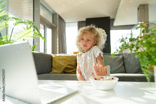Girl refusing meal watching laptop at home photo
