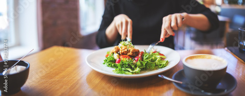 Canvas Print Woman eating a salad indoors in restaurant