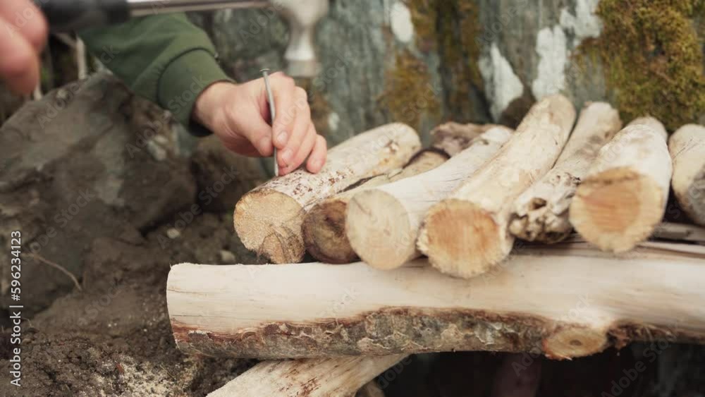 Male Hands Nailing Cut Firewood With Hammer. closeup Male Hands Nailing Cut Firewood With Hammer. closeup