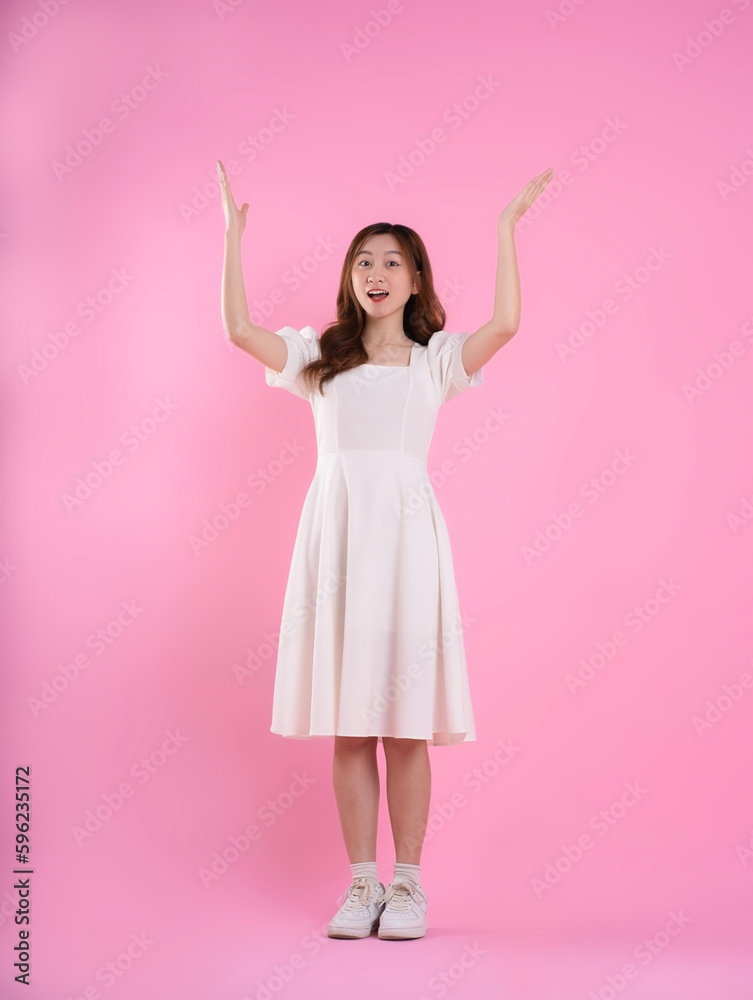 Naklejka premium full body image of asian woman in skirt posing on pink background