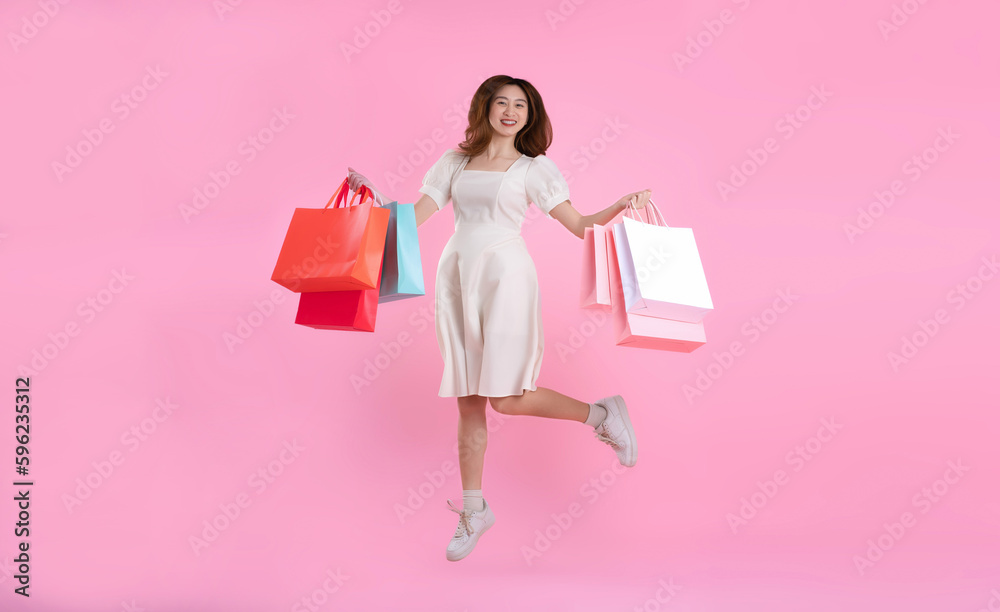 full body image of asian woman holding shopping bag and posing on pink background full body image of asian woman holding shopping bag and posing on pink background