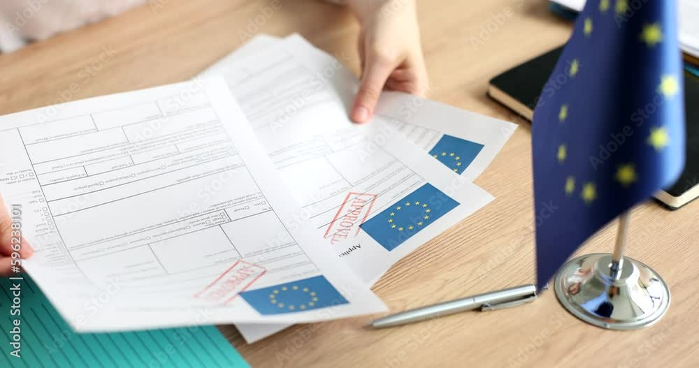 Hands holding application for schengen visa with stamp approved closeup 4k movie slow motion. Official permission to travel to European Union concept 