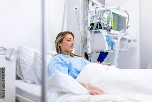 Young woman laying on bed at hospital ward. medicine, health care and quarantine concept. female patient lying in bed in hospital ward