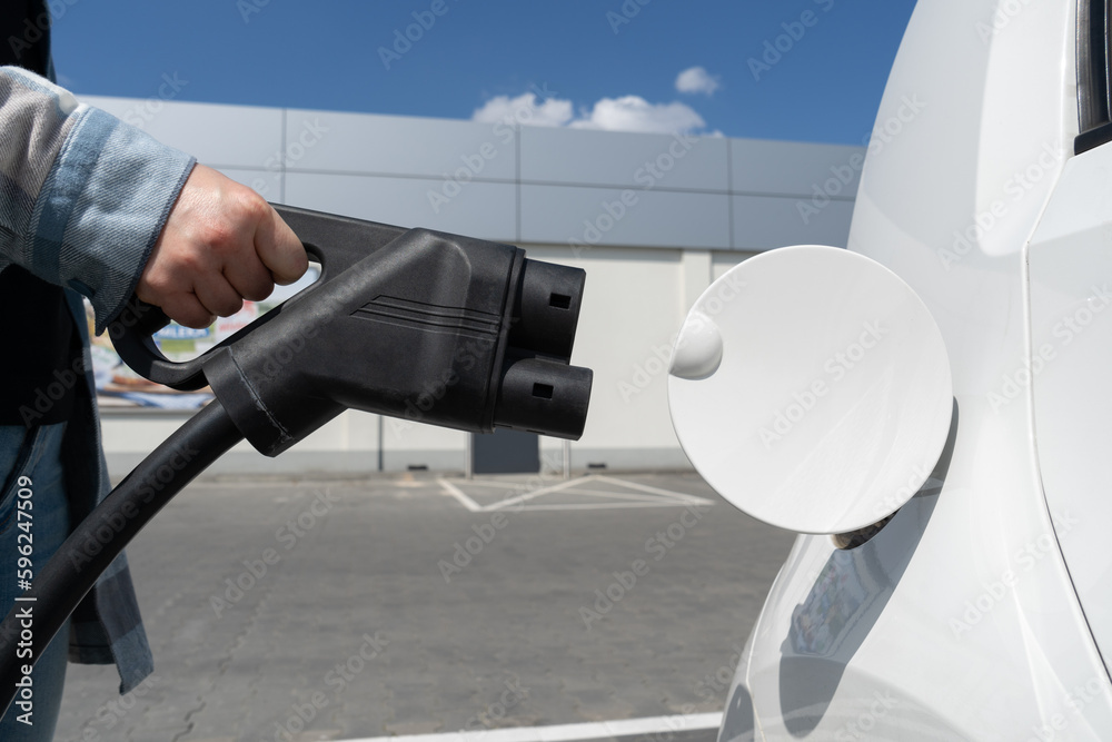 Woman holding CCS fast charging socket type 2. Combined Charging System