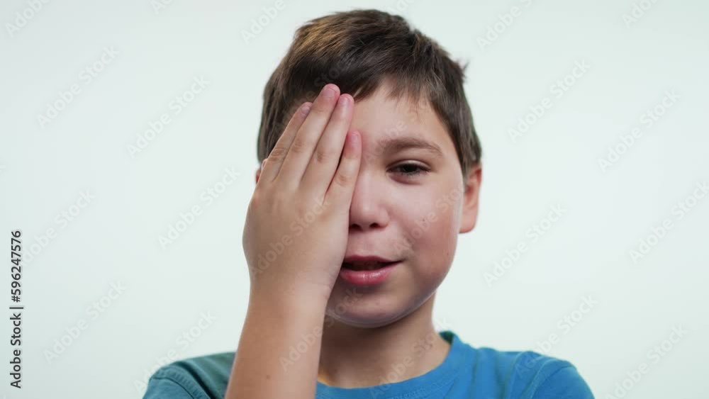 Boy closing one eye with hand, vision test