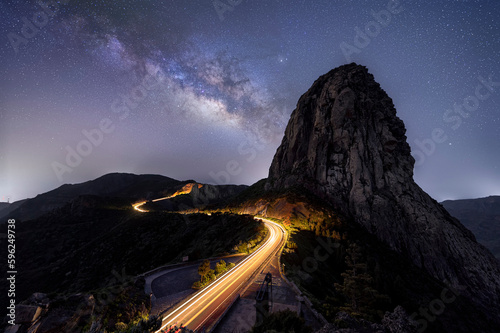 Night time image of impressive rock landscape with illuminated curved road and milky way galactic core on the Spanish canary island of La Gomera  photo