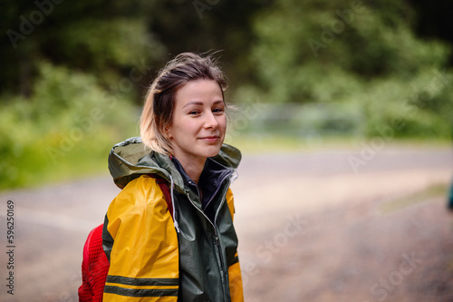 Young woman in yellow-green raincoat. Close-up portrait on road © Иванна Емельянова