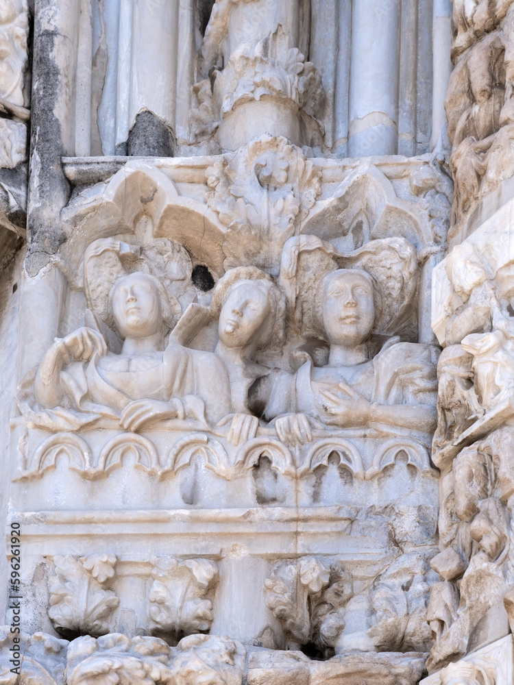 Marble details on facade of Messina Cathedral or Duomo di Messina, Sicily, Italy. Reliefs on wall picturing figures of Saints. Decorative elements in architecture