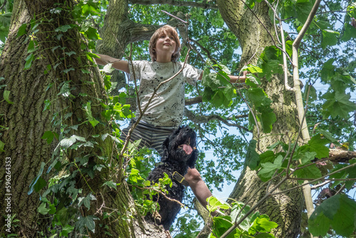 Boy with dog on leafy tree photo