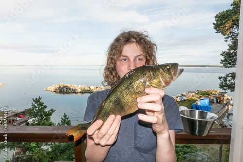 Boy holding freshly caught fish