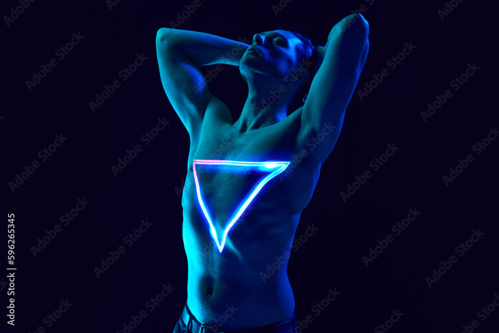 Transformation. Handsome young man with muscular body posing shirtless with neon triangle digital light reflection on body. Concept of modern photography, art, cyberpunk, techno, creativity, futurism Transformation. Handsome young man with muscular body posing shirtless with neon triangle digital light reflection on body. Concept of modern photography, art, cyberpunk, techno, creativity, futurism
