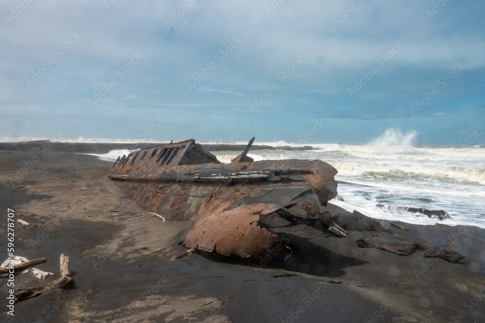 Fascinating ship wrecks on the stormy black sand beaches of the Cook Strait, North Island, New Zealand