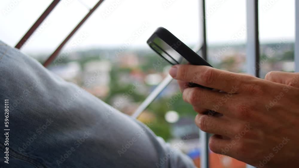 Man typing text on phone, side view Man typing text on phone, side view