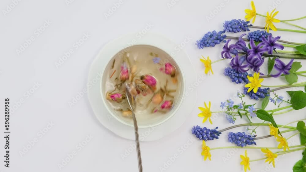 Healthy herbal tea in a white cup with medicinal herbs, flowers and Chinese tea rose buds Mei Gui Hua. Natural floral tea. Tea drinking ritual for a healthy lifestyle top view vertical video Healthy herbal tea in a white cup with medicinal herbs, flowers and Chinese tea rose buds Mei Gui Hua. Natural floral tea. Tea drinking ritual for a healthy lifestyle top view vertical video