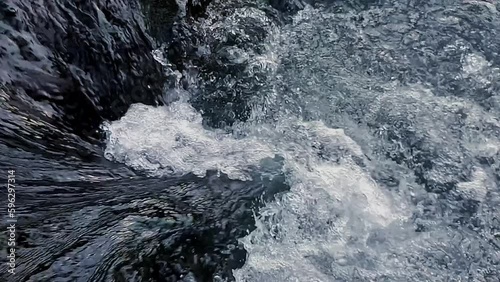 Close up pure mountain water fast flows downstream over rocks beautiful scene