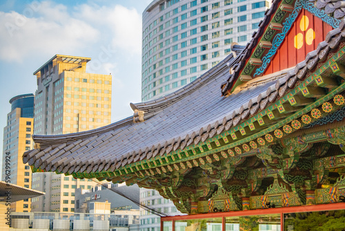 Colorful traditional Korean temple tile roof. Traditional temples and modern buildings background in Seoul. Korean temple roof details.