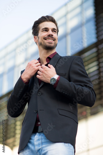 Portrait of young businessman in front of an office building	